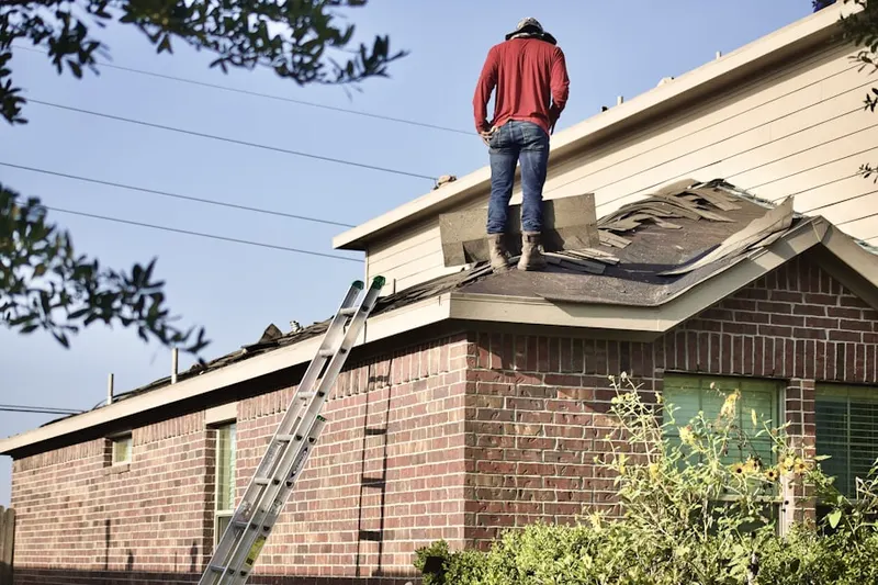 Professional roofer working on a residential roof in Houlton